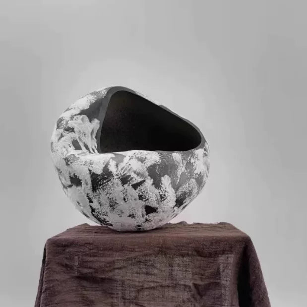 Handmade ceramic vase with a unique sculptural folded design in a neutral matte finish.