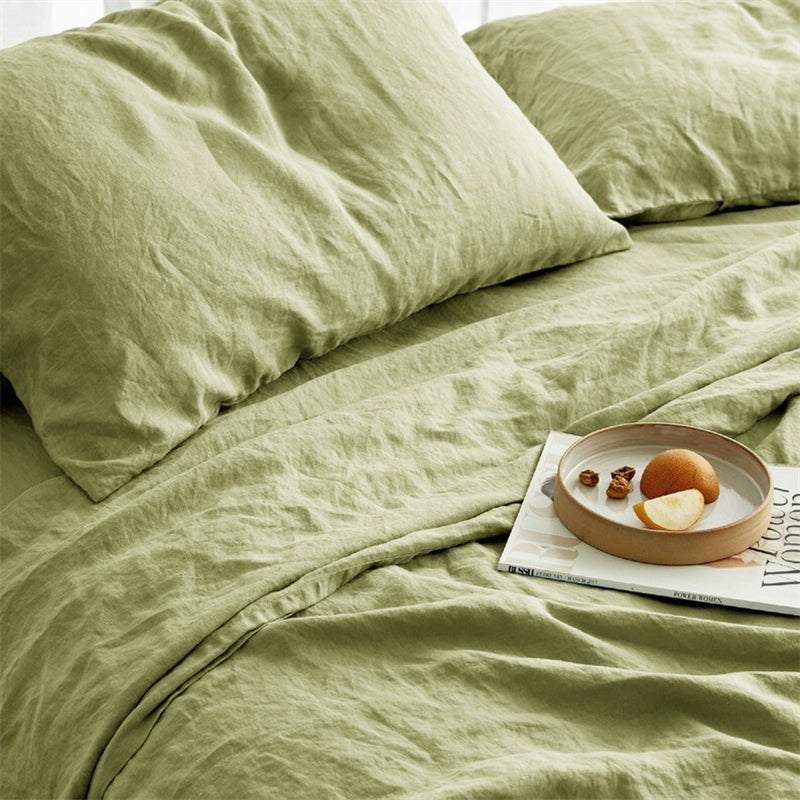 Soft sage green natural linen bedding set with pillows on a bed.