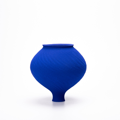 Handcrafted Klein blue ceramic vase with textured finish, on a white background.