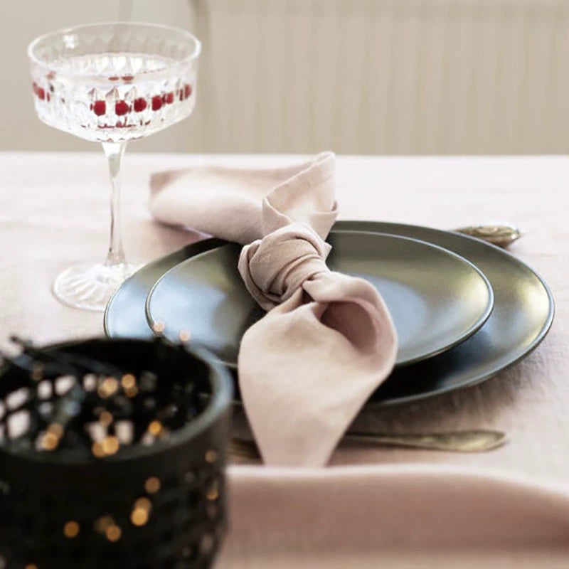 Elegant Linen Table Napkins: pink knotted napkin on dark plate, elegant table setting.