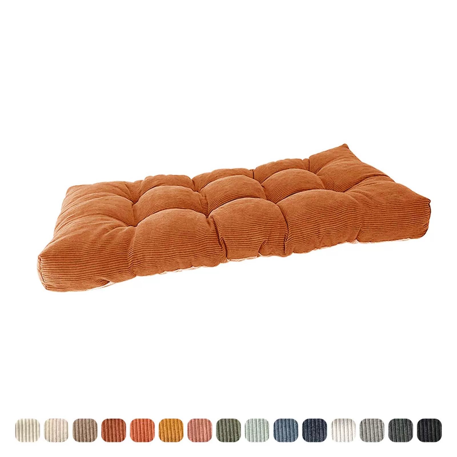 Angled perspective of a thick, tufted, corduroy bench cushion in rust orange, with color variants indicated below.