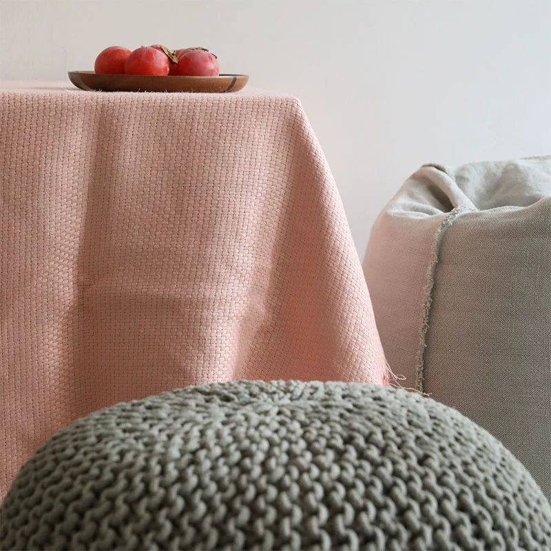 Soft pink linen throw blanket with fringes draped over furniture, home decor accent.