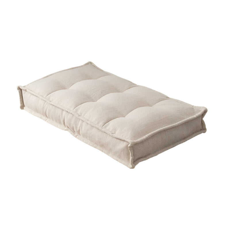 Beige rectangular cushion, tufted design,  fabric upholstery.