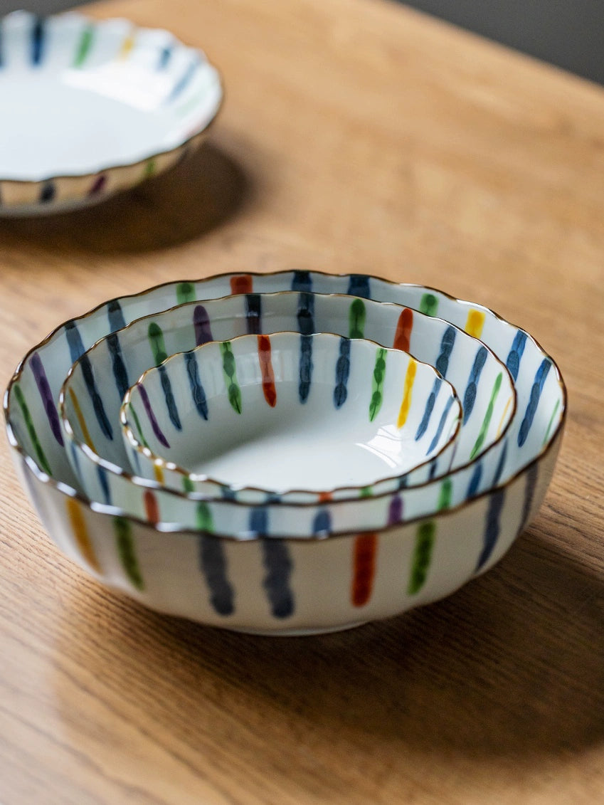 Colorful Striped Japanese Dinnerware Set bowls stacked, featuring gold trim & rustic wood background.