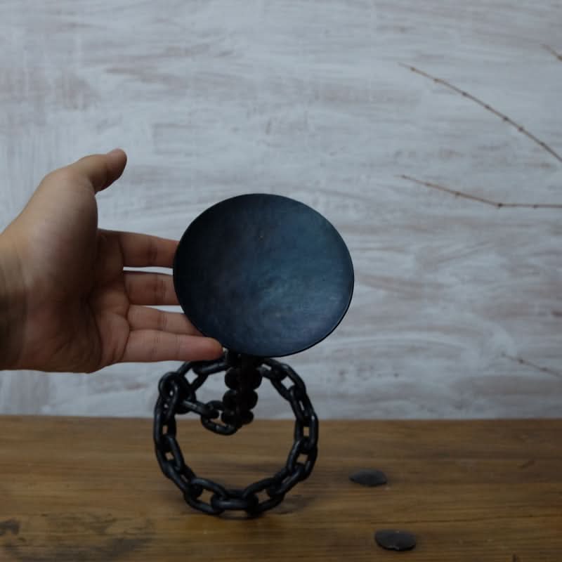 Black metal chain candle holder, perfect for industrial-style home decor.