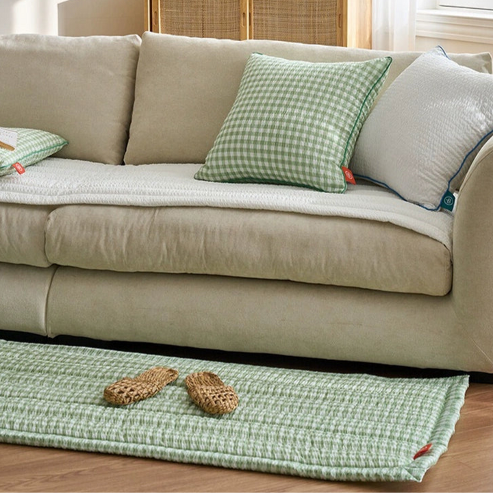 Green gingham sofa protector and rug set.  Matching green gingham pillows and white sofa.  Quilted design.  Cozy living room decor.