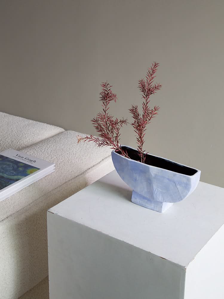 Dreamy Abstract Vase in pale blue, modern decor, holds red branches on a minimalist pedestal.