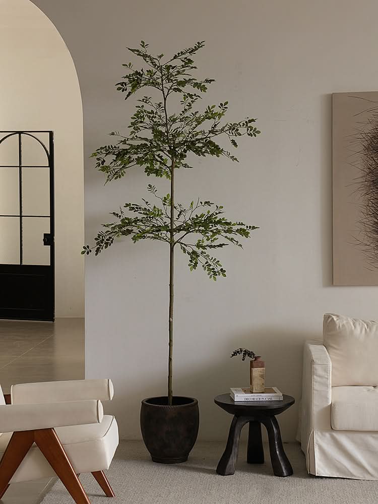 Rustic wooden side table with books and vase in a cozy living room.