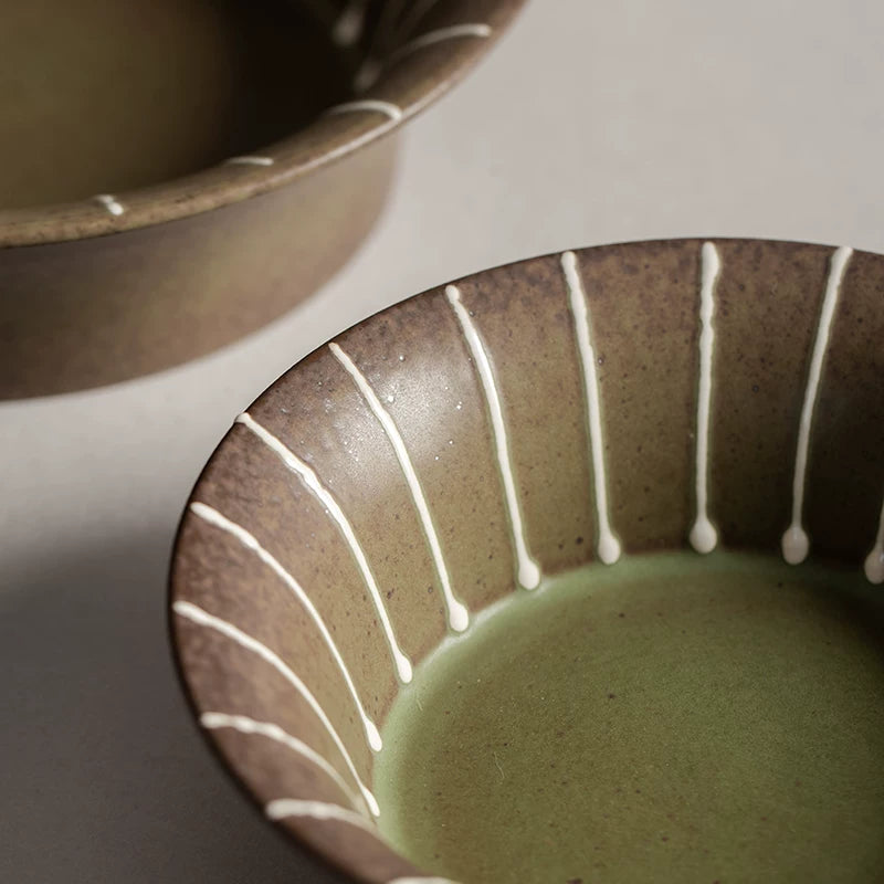 Overhead view of a 7-inch brown ceramic bowl with green interior and white vertical stripes, 17.7cm.