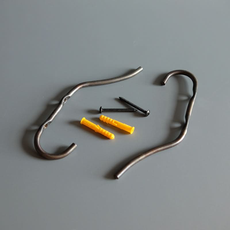 Two metal industrial style wall hooks with screws and yellow wall anchors on a gray background.
