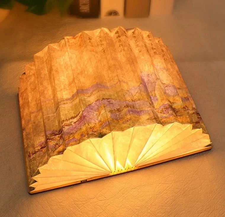Golden book paper table lamp with marble-like purple and gold pattern, open to fan shape.