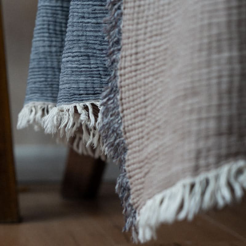 Blue and beige cotton throw blankets with fringe, cozy and versatile.