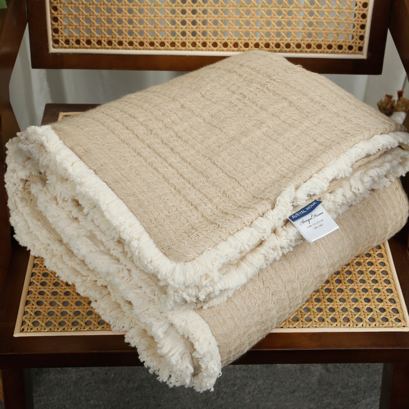 Beige linen cotton throw blanket with tassels.