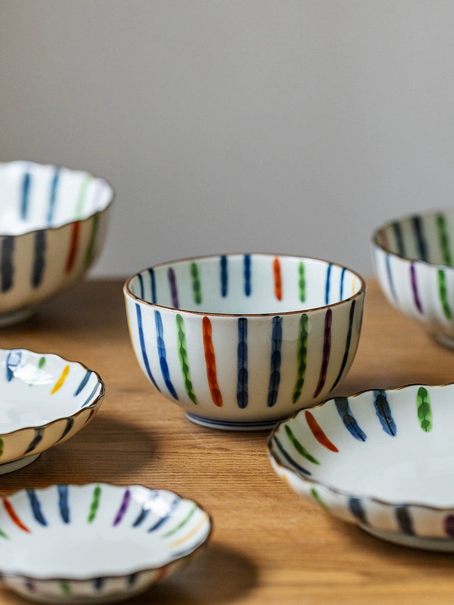 Colorful Striped Japanese Dinnerware Set with bowls and plates on wood.