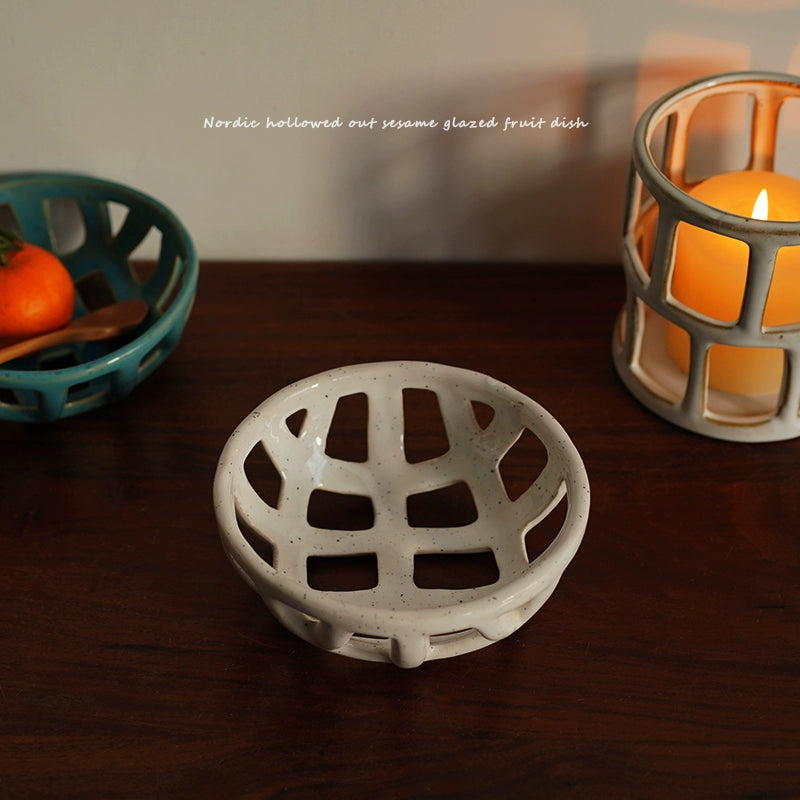 White ceramic Nordic hollowed out sesame glazed fruit dish on a wooden table.