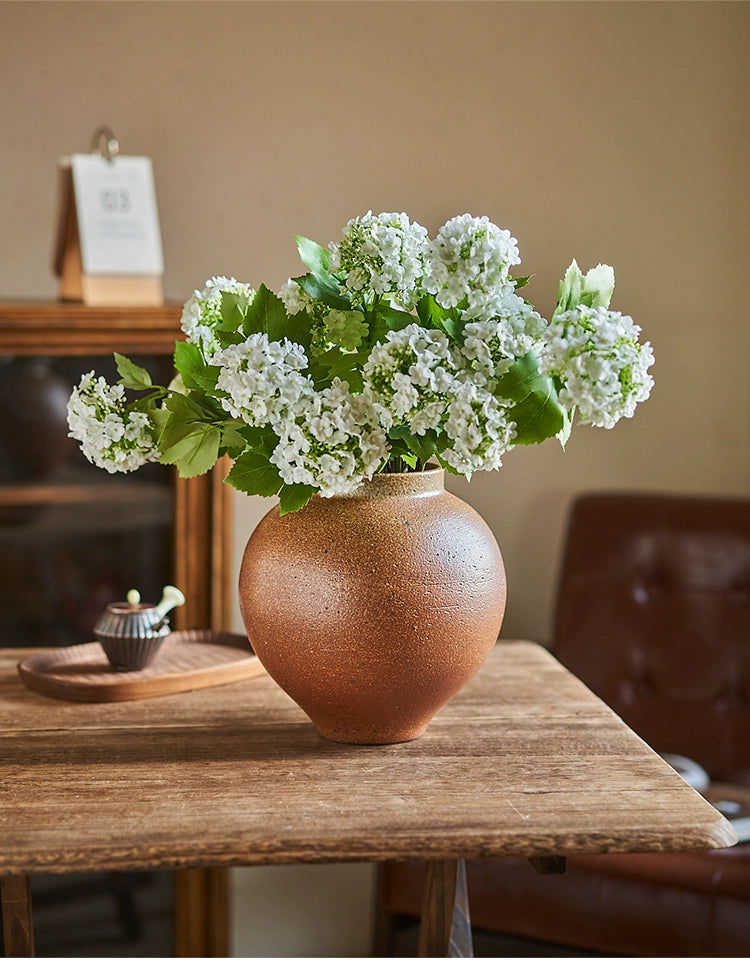 Rustic brown handmade vase, 23cm tall, with white hydrangea flowers.  Ceramic, unique texture.
