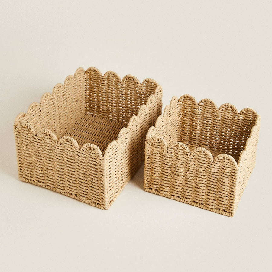 Two natural rattan storage baskets with scalloped edges.  Beige woven design.