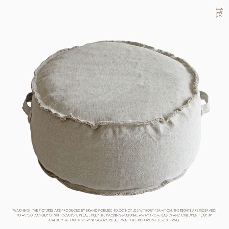 Round beige fabric ottoman pouf with decorative accent seating
