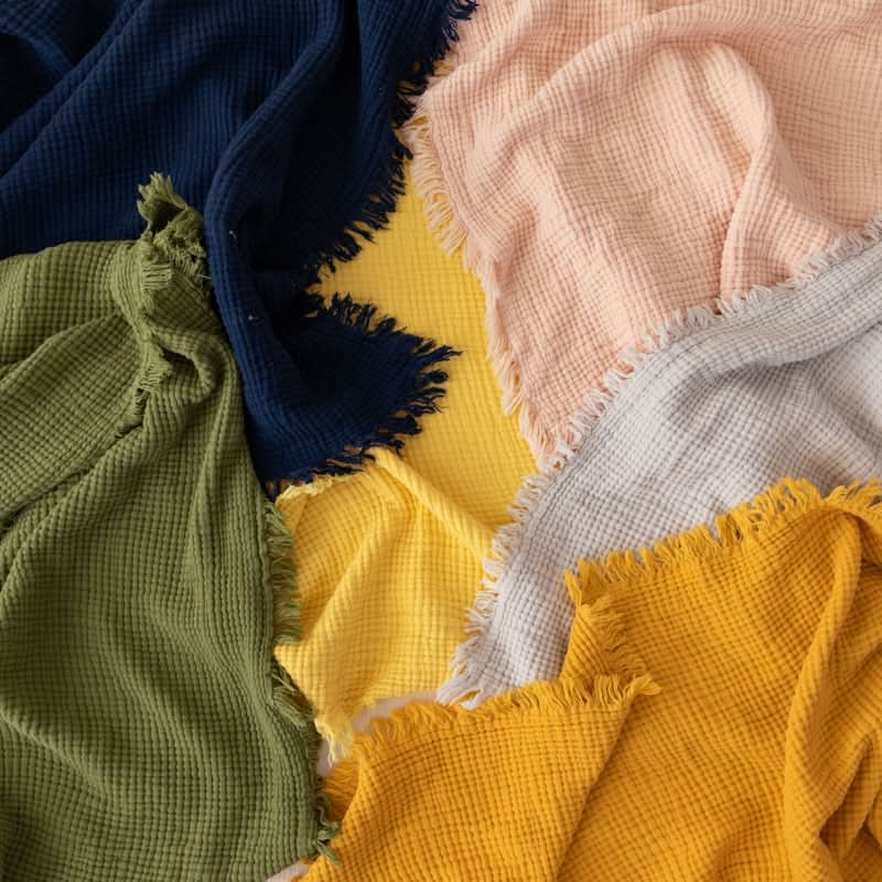 Multi-color Four-Layer Waffle Weave Cotton Throw Blanket with frayed edges.
