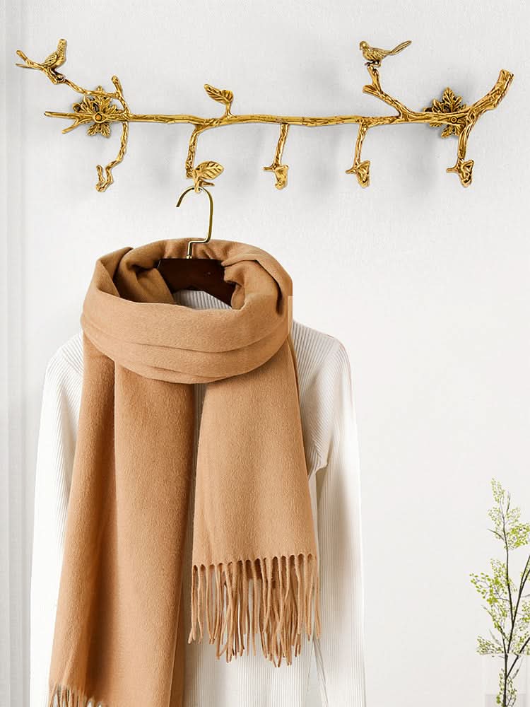 Gold vintage brass bird branch wall hooks with decorative leaves, holding a camel scarf.