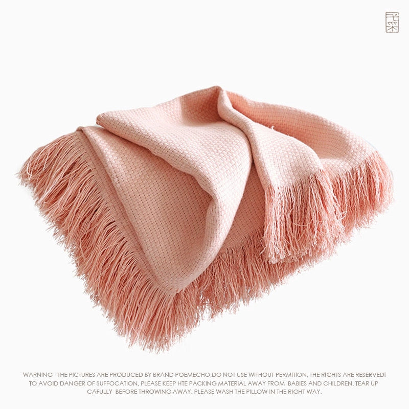 Pink linen throw blanket with fringes, soft texture, draped on white background.