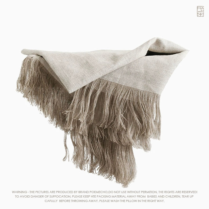 Natural beige linen table runner with fringes on a white background.