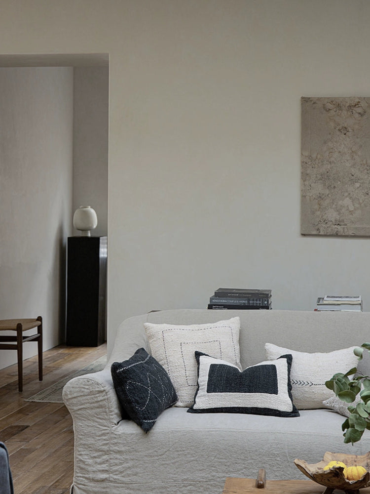 Boho Throw Pillows & Blanket Set: Beige, black, natural woven cushions on a sofa in a neutral living room.