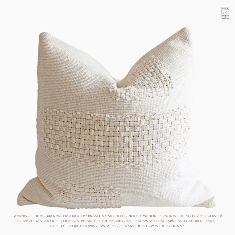 Cream woven throw pillow, featuring a textured, hand-stitched design.  Rustic style.