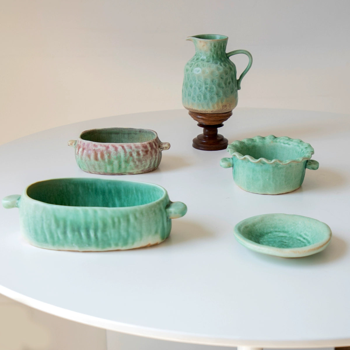 Green & rose hand-painted ceramic serving dishes, set of 5, on white table.