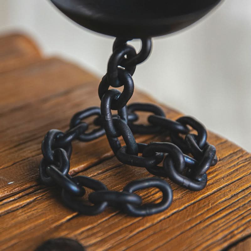 Black chain candle holder on rustic wood surface, home decor.