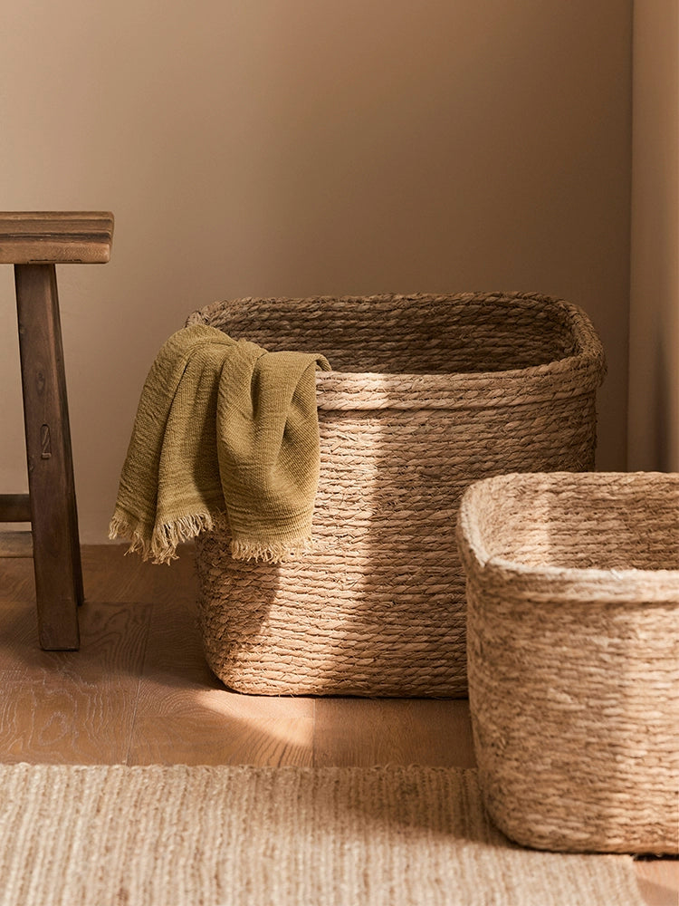 Natural rattan storage baskets set of 2, round & square, with green throw.