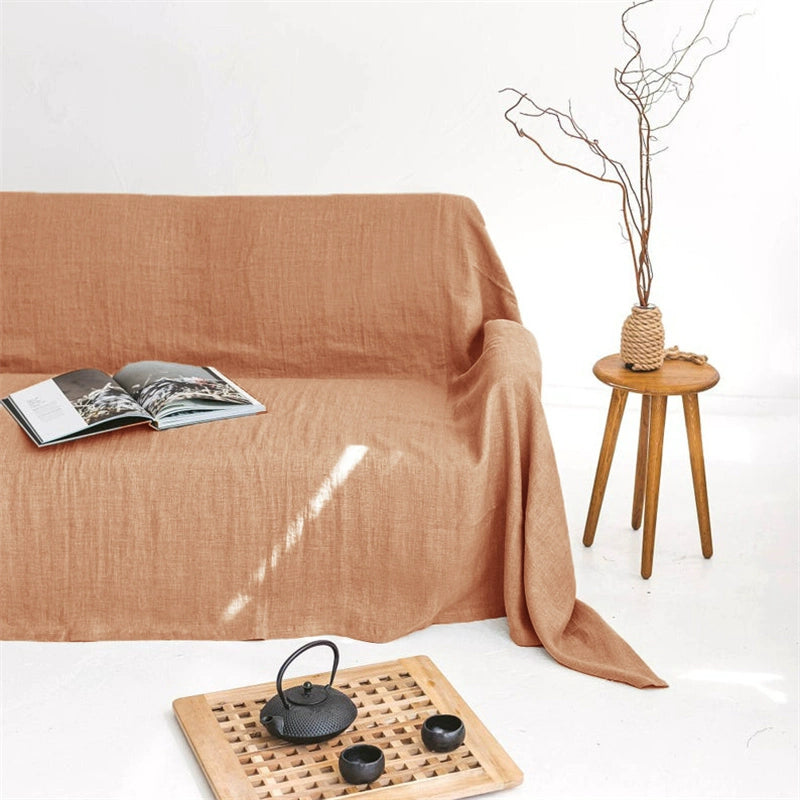 Mustard yellow linen sofa throw blanket draped on a sofa, styled with decor.