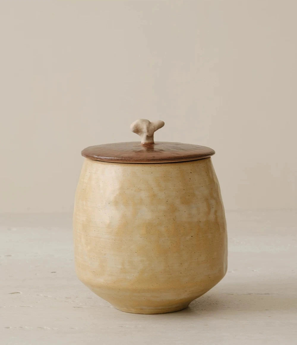 Off-white ceramic storage jar with a textured curd glaze and a natural wooden lid.