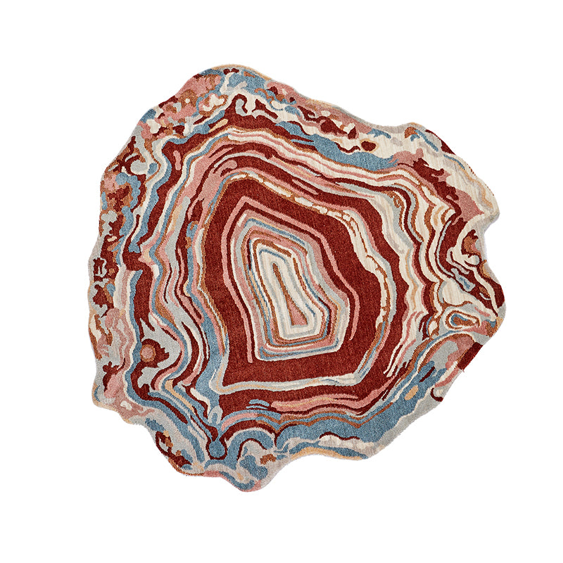 Unique abstract rug with agate-inspired design in rust, blue, pink, and cream.