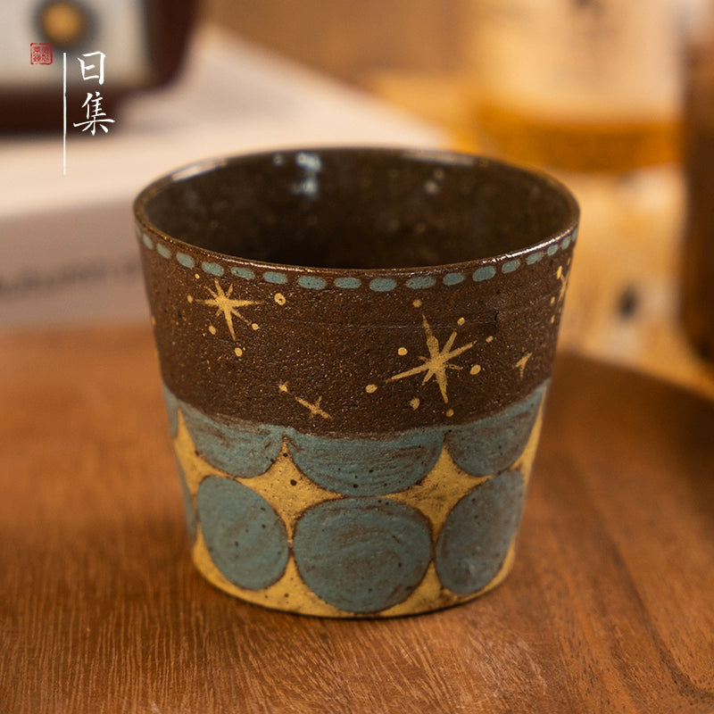 Traditional Japanese hand-painted ceramic tea cup with stars and blue motifs.