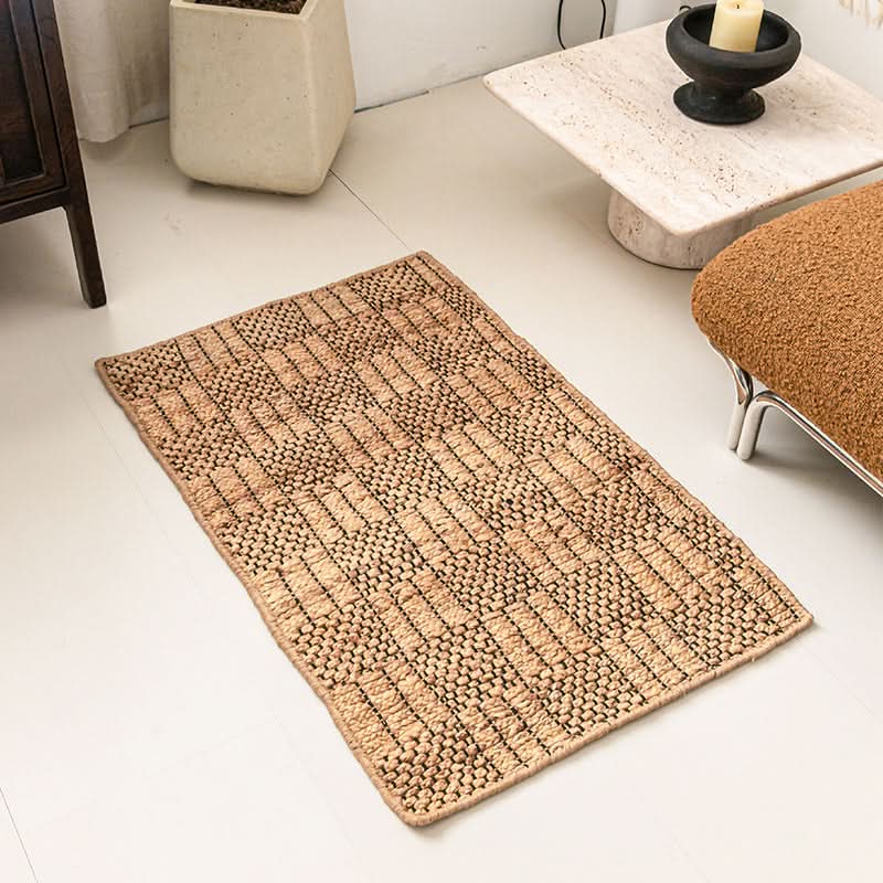 Natural woven area rug with geometric pattern in tan and black.