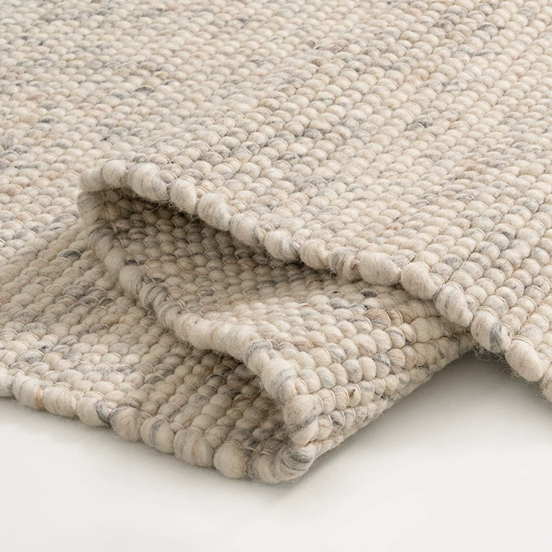 Close-up of folded wool rug showing detailed pebble weave