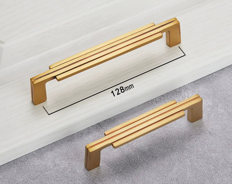 Gold colored cabinet handles with a modern minimalist design