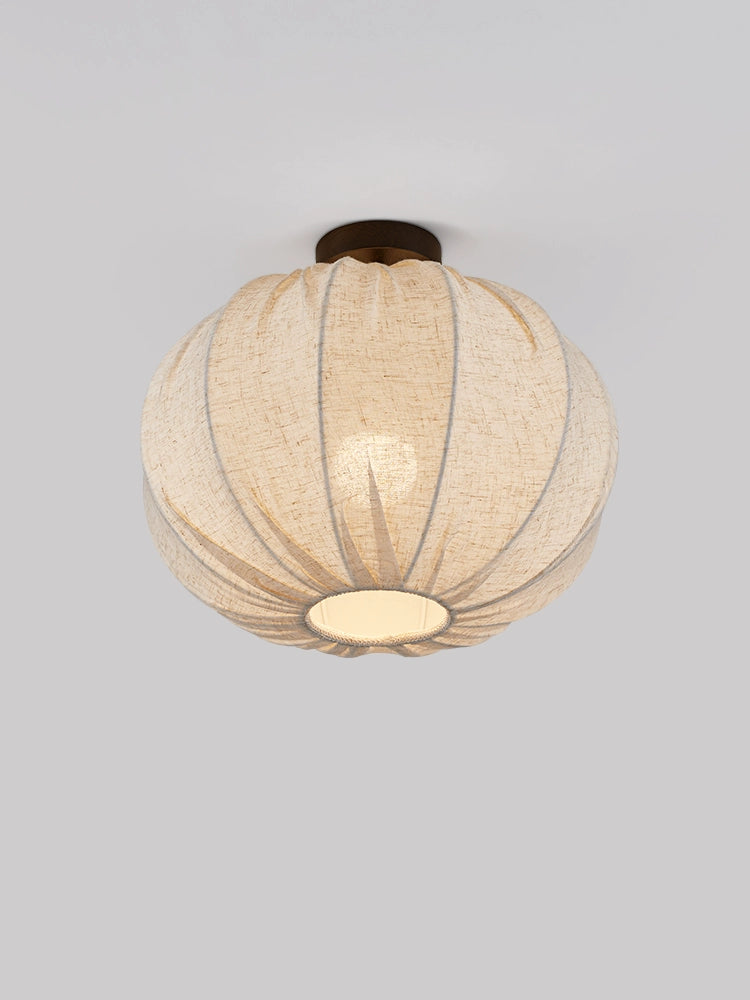Beige linen round ceiling lamp with pleated design.  Warm light, modern style.