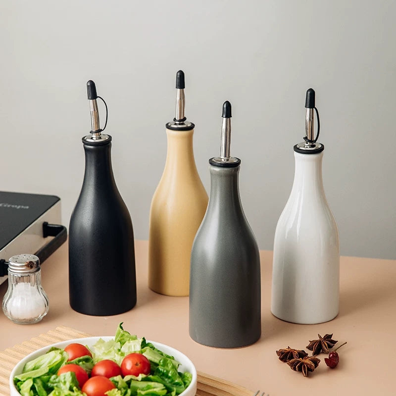 A matte ceramic oil dispenser bottle with a curved spout and a minimalist wabi-sabi design.