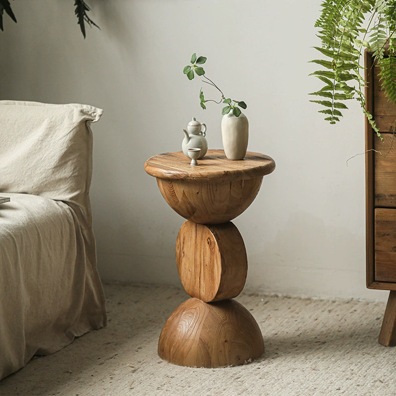 Bohemian wooden side table, round, stacked design, with teapot and vase in a living room setting.