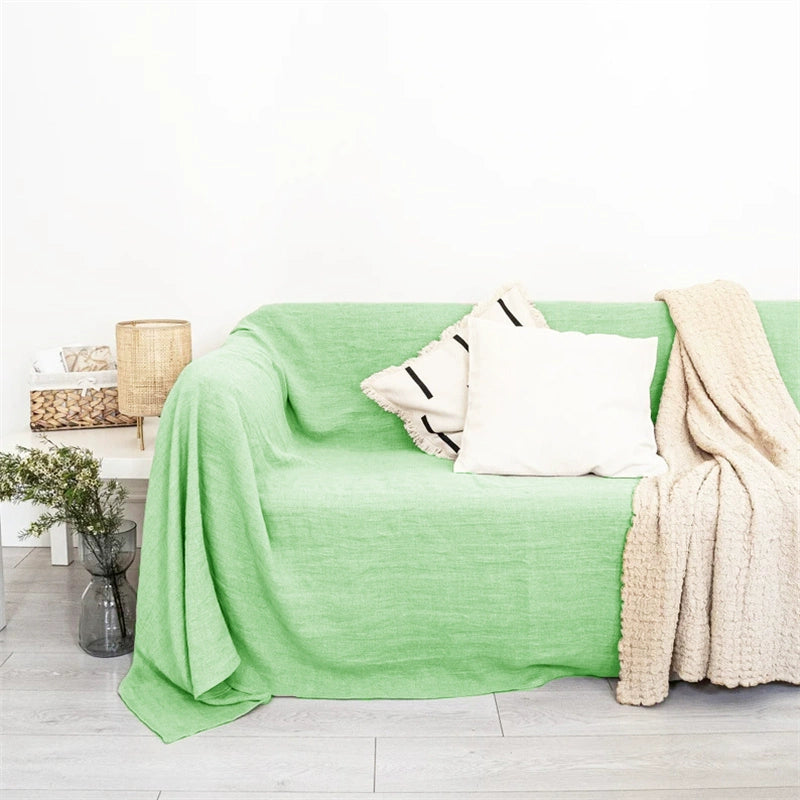 Mustard Yellow Linen Sofa Throw Blanket draped on a light green sofa with decorative pillows.