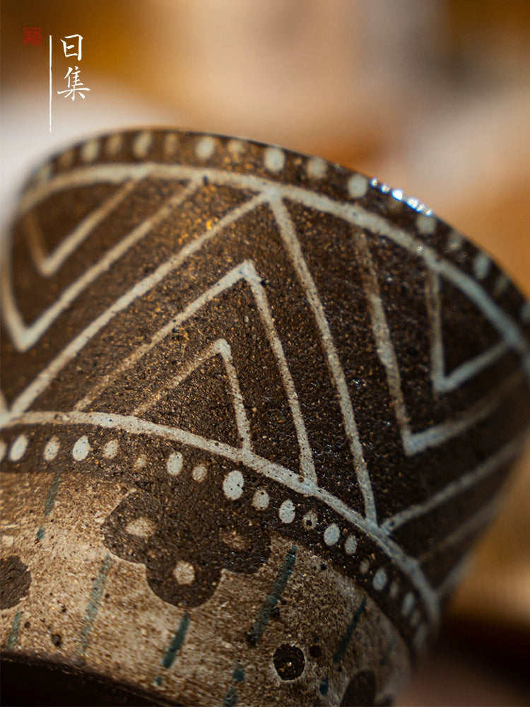 Traditional Japanese hand-painted ceramic cup with geometric designs.