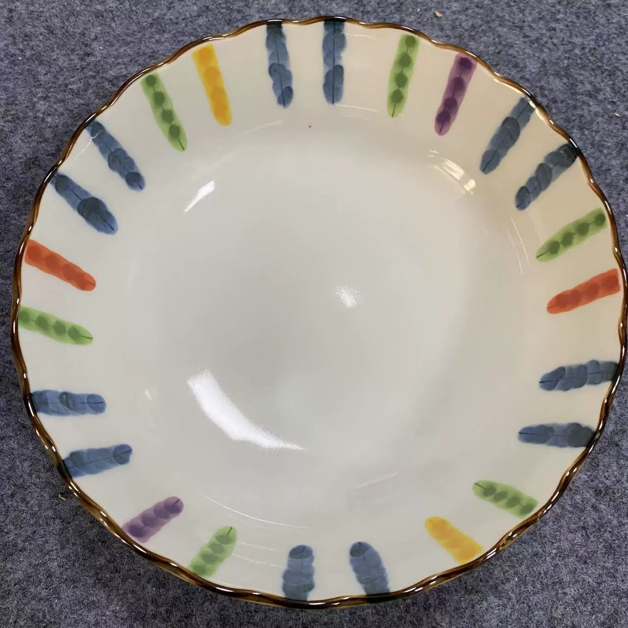 Colorful Striped Japanese Dinnerware set with wavy edges and hand-painted motifs on a grey background.