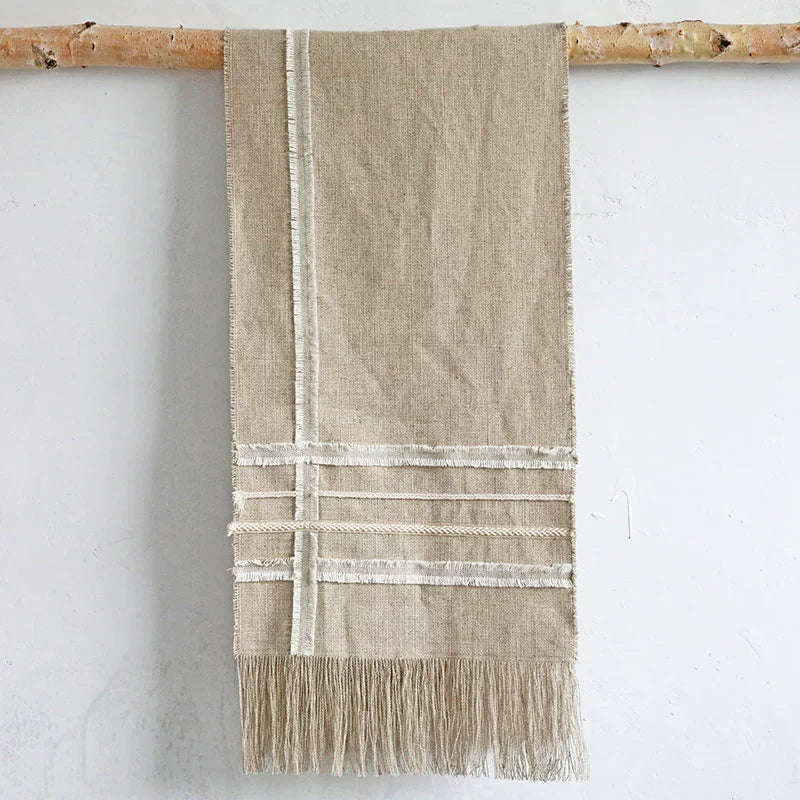 Beige linen table runner with tassels, rustic woven tablecloth decor.