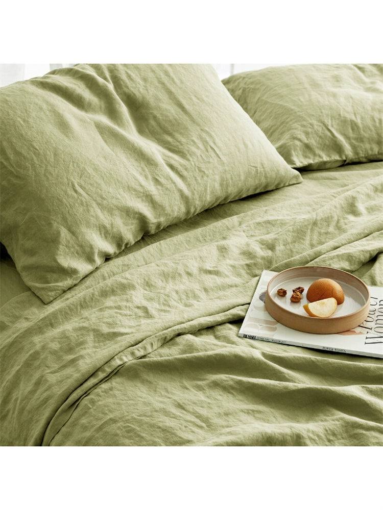 Soft sage green natural linen bedding set with a magazine and snack tray on the bed.