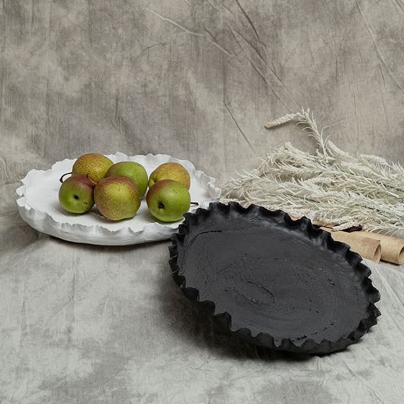 Wabi-sabi ceramic serving dish with ruffled edge, displayed with pears and dried reeds.