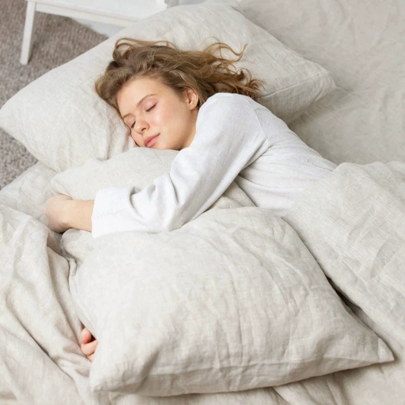 Natural linen bedding set in beige, soft & comfortable, with a woman sleeping peacefully.