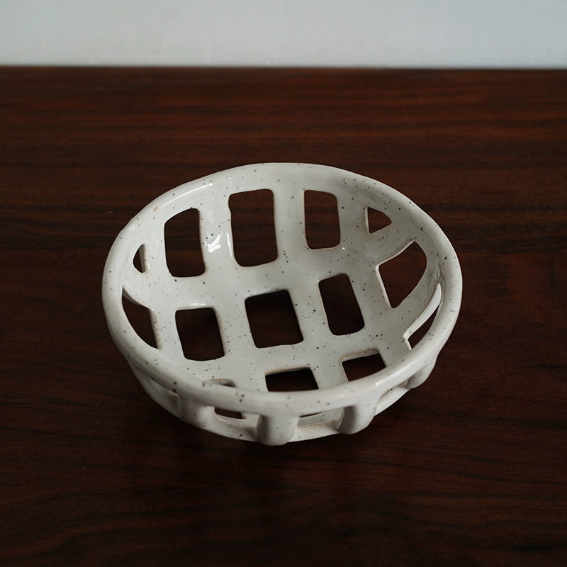 White ceramic fruit bowl with a hollowed-out lattice design.  Handmade, speckled finish.