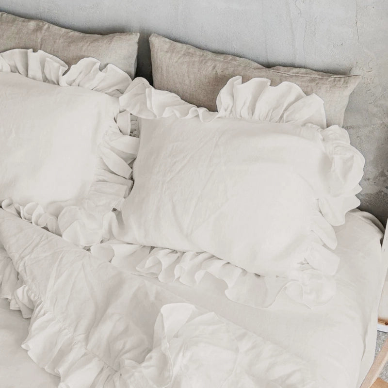 White Rustic Linen Pillowcases with Frills - Set of 2 on a bed.
